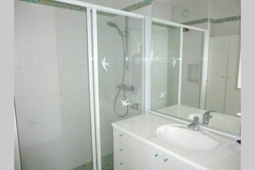 a bathroom with a shower and a sink and a mirror at F2 Climatisé Piscine Proche Plage in Cavalaire-sur-Mer