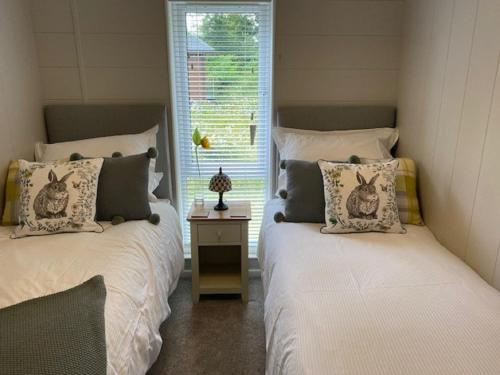two twin beds in a room with a window at Hollicarrs - Sunflower Lodge in York