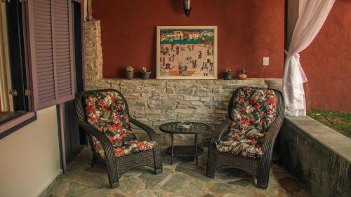 2 sillas y una mesa en una habitación en Chalés Terraviva, en Pirenópolis