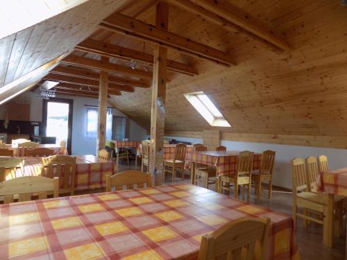 ein Esszimmer mit Tischen, Stühlen und Holzdecken in der Unterkunft Ubytování Apartmány Ferenčíková in Nové Hrady