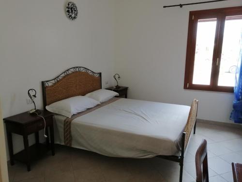 um quarto com uma cama e uma janela em Appartamento al centro di Budoni em Budoni