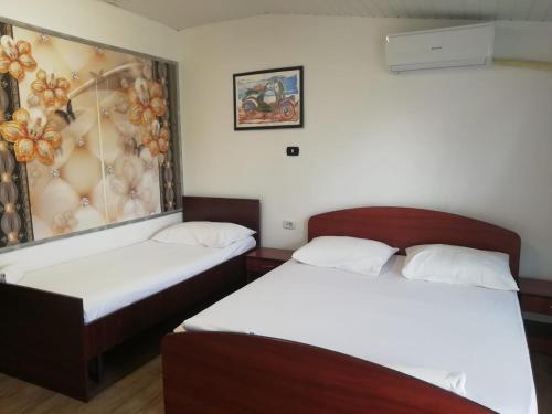 a room with two beds and a painting on the wall at Pensiunea Mario in Curtici