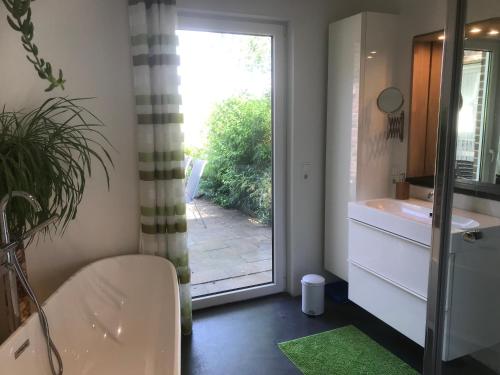 a bathroom with a tub and a sink and a window at Maison Marguerite in Lemiers