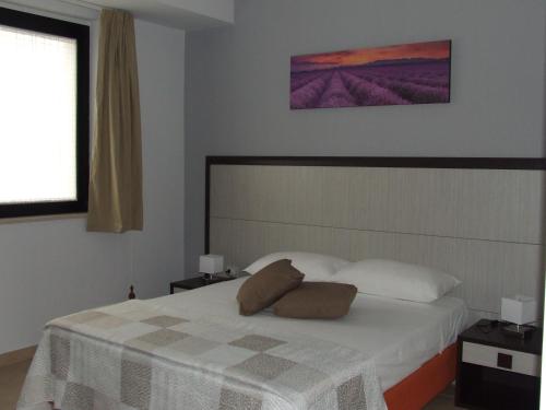 a bedroom with a bed with a white blanket and a window at L'incontro in Trinitapoli