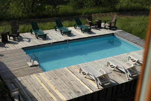 a swimming pool with chaises and chairs and a group at Котедж з неймовірними краєвидами, Карпатський Чан DREAM, Чан Джакузі in Slavske