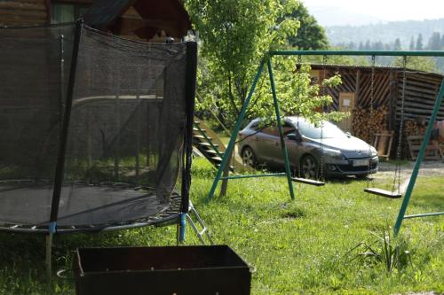 a car parked in a yard with a swing at Котедж з неймовірними краєвидами, Карпатський Чан DREAM, Чан Джакузі in Slavske
