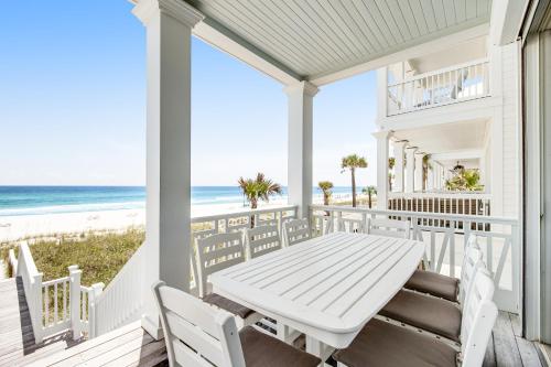 a white porch with a table and chairs and the beach at Deja Vu at Carillon in Carillon Beach