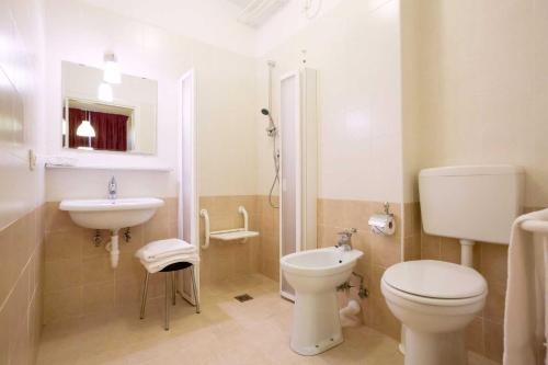 bagno bianco con servizi igienici e lavandino di Hotel Palladio a Caorle