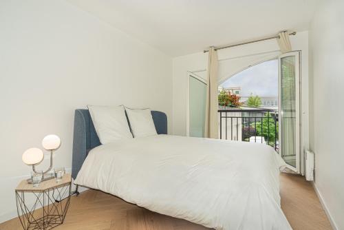 a white bedroom with a bed and a window at Disney and Paris * Netflix * Parking * 6 pers in Chessy
