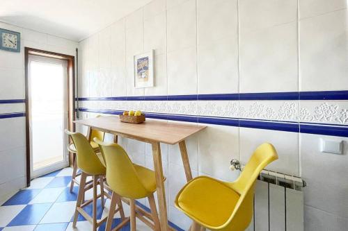 a dining room with a table and yellow chairs at Yellow House Aveiro Smart TV and garage in Aveiro