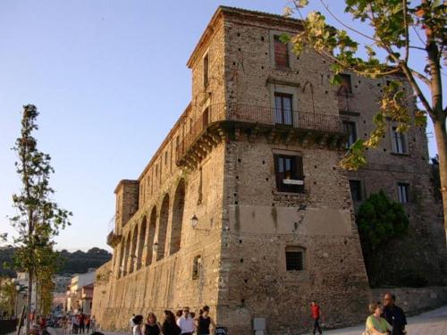 un grand bâtiment en briques avec des personnes debout devant lui dans l'établissement Appartamenti Vista Mare, à Nicotera