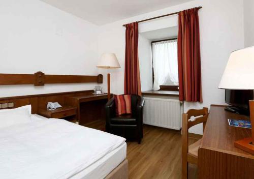 a hotel room with a bed and a desk and a chair at Jägerhof in Hannover