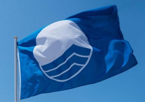 a blue and white flag flying in the sky at NIKI'S apartments in Perea