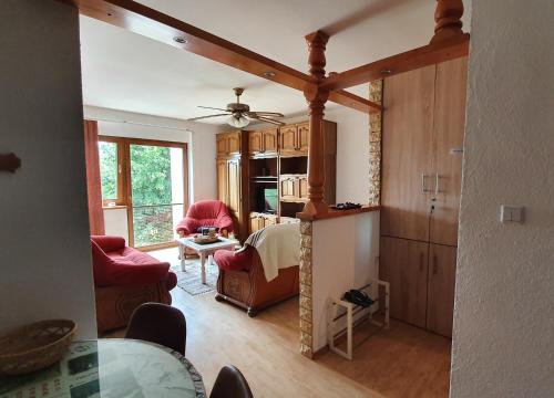 uma sala de estar com cadeiras vermelhas e uma sala de jantar em Apartman CaCO3 - Potpuno opremljen stan u blizini Plitvičkih jezera em Korenica