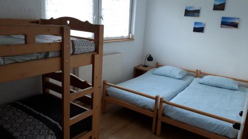 a bedroom with two bunk beds and a window at Les Jonquilles: gîte 8/10 pers. avec vue imprenable! in Gérardmer