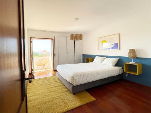 a bedroom with a white bed and a window at Yellow House Aveiro Smart TV and garage in Aveiro