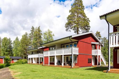 een rood-wit huis met een tuin bij Rämsbyns Fritidsområde - Den perfekta platsen för avkoppling in Idkerberget