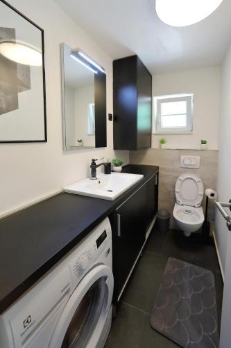 a bathroom with a sink and a washing machine at Stone Diamond in Zadar