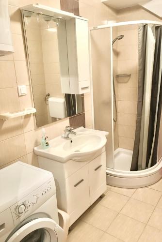 a white bathroom with a sink and a washing machine at Apartment Marie in Vrsi