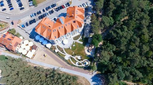 an overhead view of a large building with an orange roof at Hotel White in Krynica Morska