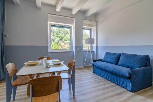 a living room with a table and a blue couch at Casa Vittoria in Agropoli