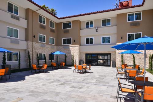 un patio con mesas y sombrillas frente a un hotel en Holiday Inn Express - Santa Rosa North, an IHG Hotel, en Santa Rosa
