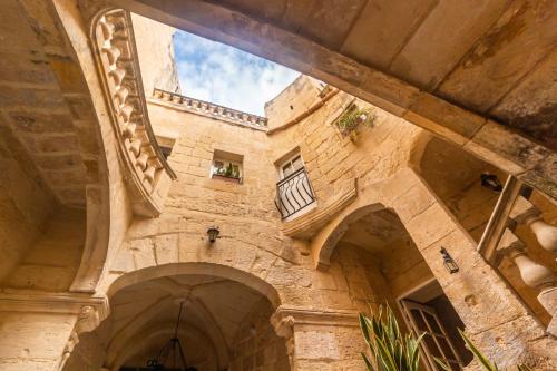 an old building with arches and a window at The Lodge in Cospicua