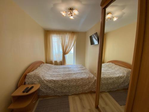 a bedroom with two beds and a mirror at Neringarent DRUSKĖ - 2-jų miegamųjų su atskiru įėjimu in Juodkrantė