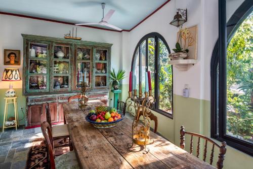 uma sala de jantar com uma mesa de madeira e uma taça de fruta em Hiraeth Santorini em Megalochori