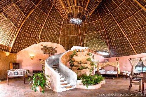 a resort lobby with a staircase and a large ceiling at The Sands at Chale Island in Chale Island