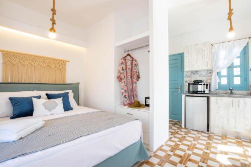 a bedroom with a bed and a kitchen at THE SHIP in Lefkos Karpathou