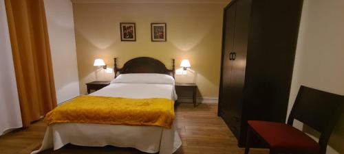 1 dormitorio con 1 cama con manta amarilla en La casa de la abuela, en Narón