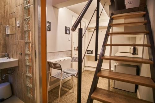 uma escada num quarto com uma cadeira e um lavatório em Z40 - Budget Apartment em Budapeste