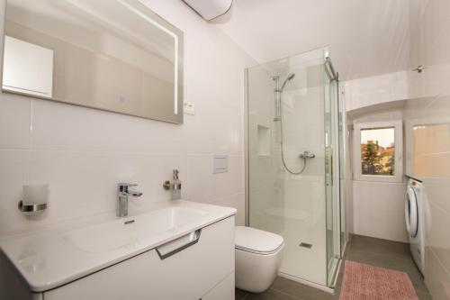 a white bathroom with a sink and a shower at Antique center Pula in Pula