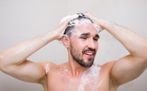 Un hombre se está lavando el pelo en la ducha. en Mayflower Motel Milford, en Milford