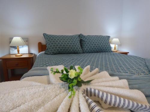 a bedroom with a bed with a bouquet of flowers on it at Apartamento Rosa in Vila Nova de Milfontes