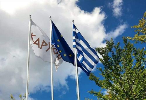 two european flags are flying in the sky at Karyon Apartments in Kariófiton