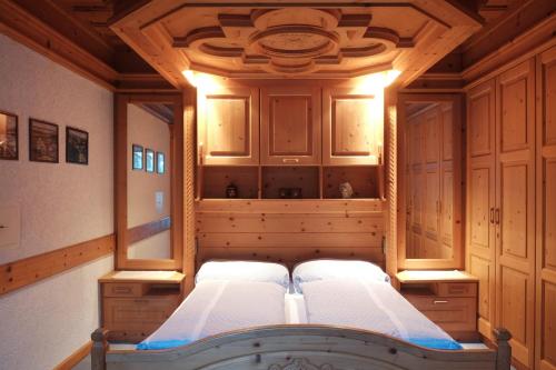 a bedroom with two beds and wooden cabinets at Ferienwohnung Mühlmann in Außervillgraten