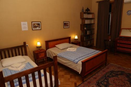 a bedroom with two beds and a book shelf at Sun Guest House in Kutaisi