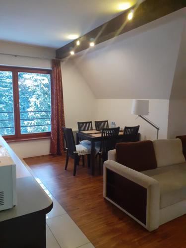 salon z kanapą, stołem i krzesłami w obiekcie Apartament Hiszpański w Zakopanem