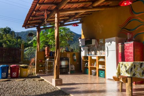 a patio with a wooden pergola and a refrigerator at Greensoul Hospedagem in Ubatuba