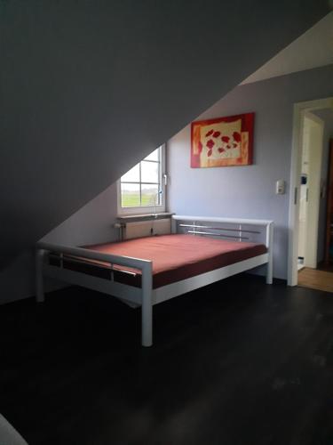 a bed in a room with a window at Ferienwohnung auf dem Land in Wangerland