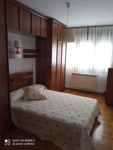 a bedroom with a bed and a large window at APARTAMENTO RAFER in Ribadeo