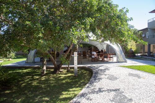 a group of people sitting at a table under a tree at Pousada Aguas Claras in Búzios