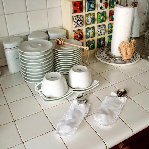 a kitchen counter with white dishes and utensils at CASA VACANZA LA VILLA in Amelia