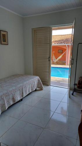a bedroom with a bed and a view of a pool at Pousada Casa Doce Vida in Águas de Lindóia