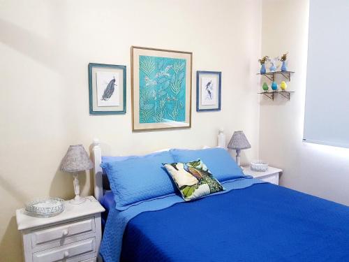 a bedroom with a blue bed and two night stands at Tudo proximo Botafogo in Rio de Janeiro