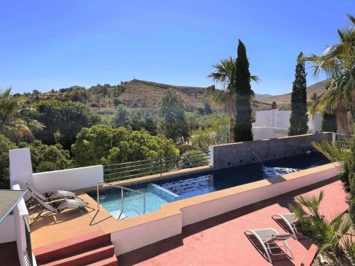 a house with a swimming pool and palm trees at Mdina in Fernán Pérez