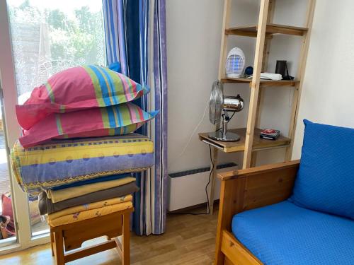 Zimmer mit einem Stuhl, einem Kissen und einem Fenster in der Unterkunft Soustons plage Maison terrasse 2 pers et 1 enfant Les villas du lac Tennis mini golf in Soustons