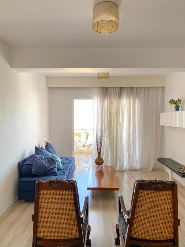 - un salon avec un canapé bleu et deux chaises dans l'établissement Summer getaway: Stunning 1 bedroom apartment!, à Pólis Chrysochoús